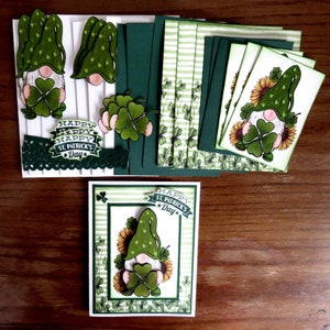 May include: St. Patrick's Day themed paper crafts. The image shows a collection of handmade cards, cutouts, and decorative elements. The designs feature gnomes, shamrocks, and sunflowers in green, white, and yellow. The phrase "Happy St. Patrick's Day" is also visible.