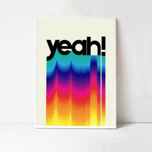 May include: A colorful graphic print with the word "yeah!" in black text. The background is a gradient of yellow, orange, red, pink, purple, blue, and green.