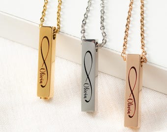 May include: Three personalized bar necklaces in gold, silver, and rose gold. Each necklace features an infinity symbol and the name "Olivia" engraved on the bar pendant. The necklaces hang on delicate chains.
