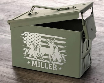 May include: A green metal ammo can with a hinged lid. The can has a white deer silhouette with antlers, a distressed American flag, and the name "MILLER" engraved on the front.