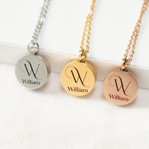 May include: Three personalized round pendant necklaces in silver, gold, and rose gold. Each pendant features the letter "W" and the name "William" in a script font. The necklaces are displayed on a white surface.
