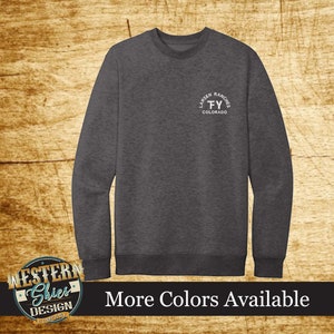 May include: A dark heather grey long-sleeve sweatshirt with a white circular logo on the left chest. The logo reads "Larsen Ranches FY Colorado".