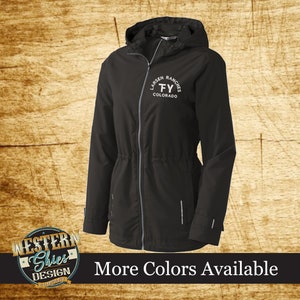 May include: Black hooded jacket with a zipper closure and a drawstring waist. The jacket has a white embroidered logo that says "Larsen Ranches TY Colorado".