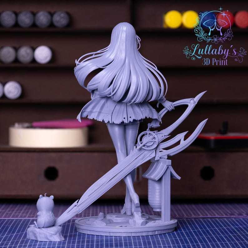 May include: A light gray 3D-printed figurine of a female character with long flowing hair, a short skirt, and holding a large, ornate sword. A small bear-like figure is on a rock at the base. The figurine is on a round base.
