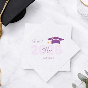 Op de afbeelding: Een vierkant wit papieren servet met een paars icoon van een afstudeerhoed, de tekst "Class of", de naam "Chloe", de grote lichtpaarse cijfers "2026" en de datum "11.06.2026" gedrukt in een donkerpaars script en schreefloos lettertype.