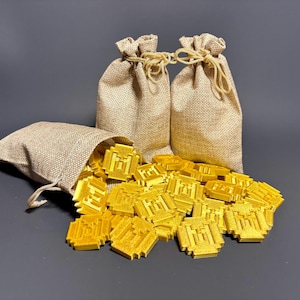 May include: Two burlap sacks overflowing with gold-colored plastic coins. The coins are shaped like a castle with a tower.