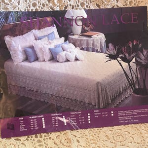 May include: A product advertisement for Shannon Lace bedding featuring a bed with a white lace bedspread, matching lace shams, and light blue accent pillows. The bottom section includes a size chart for blanket covers, dust ruffles, and pillows.