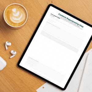 May include: A digital tablet displaying a "Content Repurposing Map" with text and a grid layout. A cup of coffee with latte art, a coaster, and wireless earbuds are on a wooden surface.