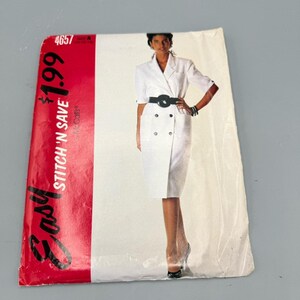 Könnte beinhalten: Ein Vintage-Schnittmuster für ein weißes Kleid mit schwarzem Gürtel. Das Schnittmustercover hat ein rot-weißes Design mit den Worten "Easy Stitch 'N Save". Das Model trägt ein weißes Kleid mit doppelreihigem Design.