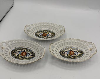 Set di 3 piattini portagioie vintage in porcellana tedesca, decorati con motivi floreali traforati e bordo dorato.
