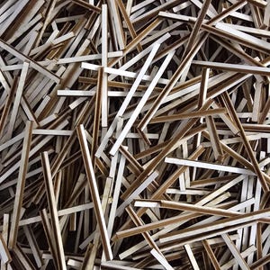 May include: A pile of brown and white wooden strips, likely used for crafts or model building.