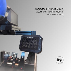 Pode incluir: Um Elgato Stream Deck preto montado numa estrutura de perfil de alumínio. O texto diz: ELGATO STREAM DECK ALUMINIUM PROFILE MOUNT (FOR MK1 & MK2). O dispositivo possui uma grelha de quinze botões quadrados fixada num suporte de metal preto.