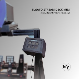 Könnte beinhalten: Ein schwarzes Elgato Stream Deck Mini mit sechs Tasten, montiert auf einem Aluminiumprofil. Der Text "ELGATO STREAM DECK MINI" und "ALUMINIUM PROFILE MOUNT" sind zu sehen. Ein Custom Key-Logo ist sichtbar.