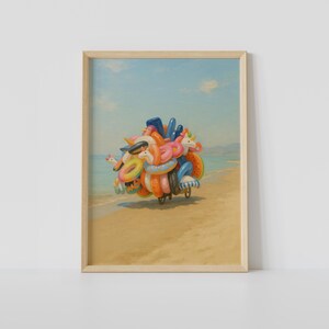 Puede incluir: Un cuadro enmarcado que representa un carro cargado de flotadores de piscina coloridos, incluyendo unicornios y anillos, sobre una playa de arena cerca del océano bajo un cielo azul claro con nubes suaves, en un marco de madera clara.