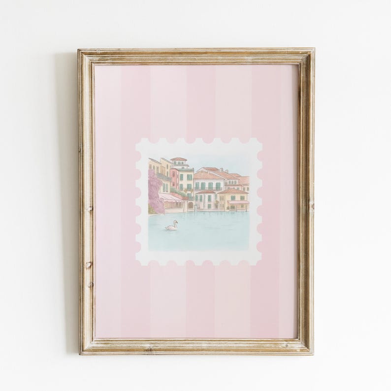 Pu&ograve; includere: Una stampa incorniciata con un'illustrazione ad acquerello di una scena sul lungomare europeo, simile a un francobollo. L'opera d'arte &egrave; ambientata su uno sfondo a righe rosa e incorniciata in una cornice di legno dorato. L'immagine raffigura edifici, acqua e un cigno.