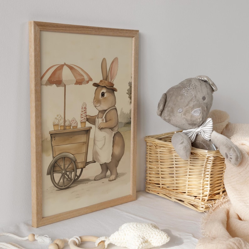 May include: A framed illustration of a brown rabbit wearing a hat and apron, pushing a cart with ice cream cones. The rabbit is standing on a path with green grass and a blue sky in the background.