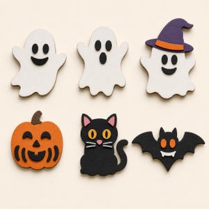 May include: A set of six flat Halloween-themed wooden cutouts including two white ghosts, one white ghost wearing a purple witch hat with an orange band, an orange jack-o'-lantern, a black cat with pink ears, and a black bat with orange eyes.