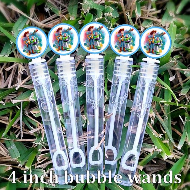 Op de afbeelding: Vijf 10 cm lange, doorzichtige plastic zeepbelstokjes met blauwe en witte ronde labels met een cartoon afbeelding van Woody en Buzz Lightyear uit de Toy Story-filmfranchise.