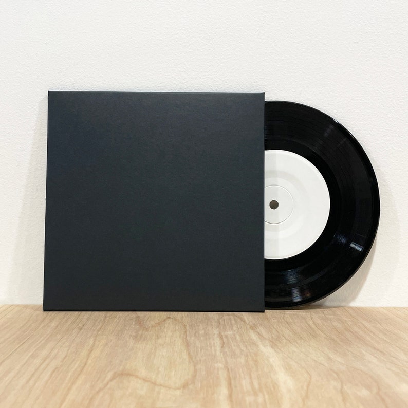 May include: A black 45 rpm record with a white label in a black paper sleeve.