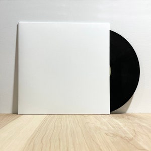 May include: A white record sleeve with a black vinyl record inside.