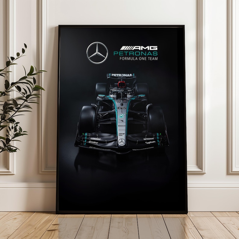 May include: A framed poster featuring a Formula One race car. The car is black with teal and silver accents, and the Mercedes-Benz logo is visible. The poster also includes the text "AMG Petronas Formula One Team."
