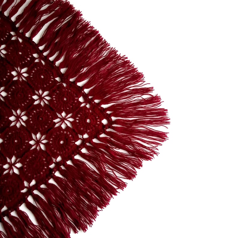 The image highlights the fringe tassels along the bottom edge of an evening shawl.
