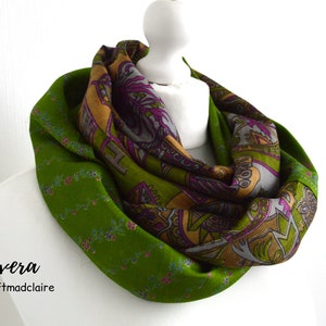 May include: A green and brown infinity scarf with a floral pattern. The scarf is reversible and has a paisley design on one side and a floral design on the other. The scarf is made of soft, comfortable fabric and is perfect for adding a touch of style to any outfit.