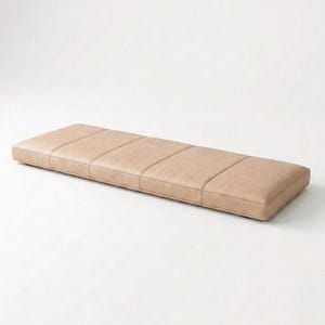 May include: A rectangular, light tan bench with a padded, tufted design. The bench is low to the ground and has a simple, modern aesthetic. The bench is approximately 60 inches long.