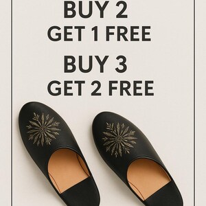May include: Black leather slippers with a gold embroidered floral design. The image includes text that reads "SPECIAL OFFER! BUY 2 GET 1 FREE BUY 3 GET 2 FREE" and "MIX AND MATCH ANY SANDALS OR SLIPPERS IN OUR SHOP."