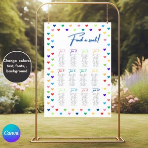 Peut inclure: Un plan de table blanc avec une bordure de cœurs colorés, présenté sur un support en métal doré. Le tableau comporte le texte "Find a seat!" en écriture bleue, avec les numéros de table et les noms des invités. L'arrière-plan est une scène extérieure floue.