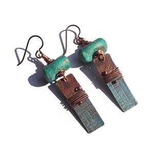 May include: Teal and copper earrings with a textured copper rectangle and a teal bead. The earrings have a wire wrapped around the copper rectangle.