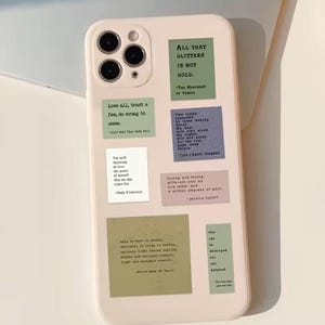 May include: A pale pink phone case adorned with several square stickers in different colours, each bearing quotes. These include phrases such as "All that glitters is not gold" and "Love all, trust a few, do wrong to good."