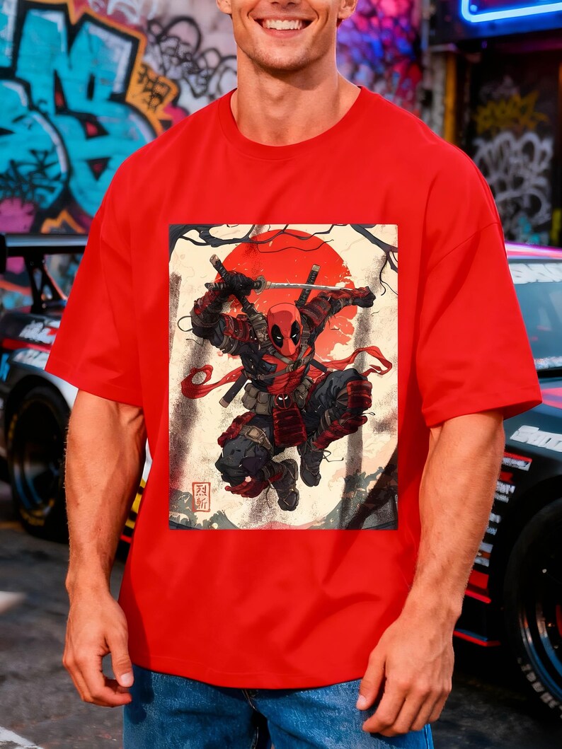 Puede incluir: Camiseta roja con un dise&ntilde;o de Deadpool en una pose de samur&aacute;i, con un sol rojo de fondo. El dise&ntilde;o incluye espadas y texto japon&eacute;s. La camiseta es de color rojo liso.