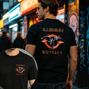 May include: A black t-shirt featuring a graphic print of a winged figure centered within a red and orange circular design. The text ILLENIUM is printed above the graphic, and the word ODYSSEY is printed below it in a stylized orange font.