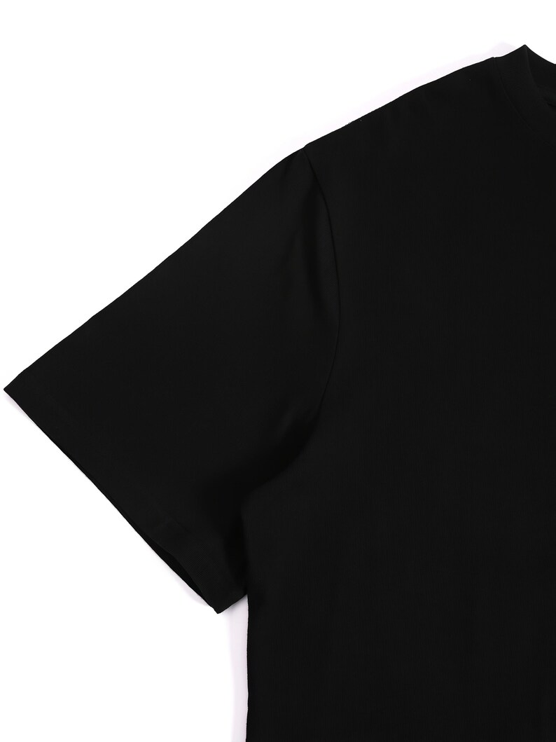 Puede incluir: Una camiseta negra lisa de manga corta. La imagen muestra el hombro y la manga de la camiseta sobre un fondo blanco. La camiseta est&aacute; hecha de una tela lisa y opaca. El dise&ntilde;o es simple y cl&aacute;sico.