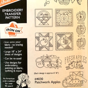 May include: Iron-on embroidery transfer pattern sheet featuring patchwork apple designs. The sheet includes a variety of designs, including apples in baskets, apples with hearts, and apples with the words "Picked with Love" and "Fresh Apples 5c". Each design is approximately 6 inches by 8 inches.