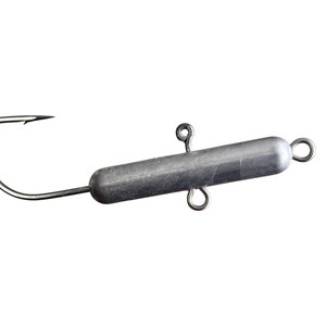 May include: Close-up of a fishing hook with a silver-colored cylindrical weight attached. The hook is sharp and curved, designed for catching fish. The weight has two small loops and a single loop for attachment.