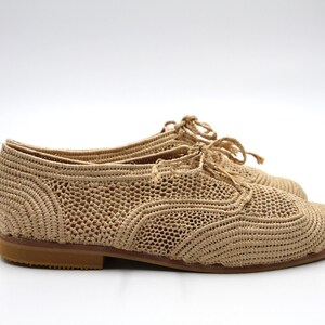 May include: Beige crocheted lace-up shoes with a rounded toe and a low heel.