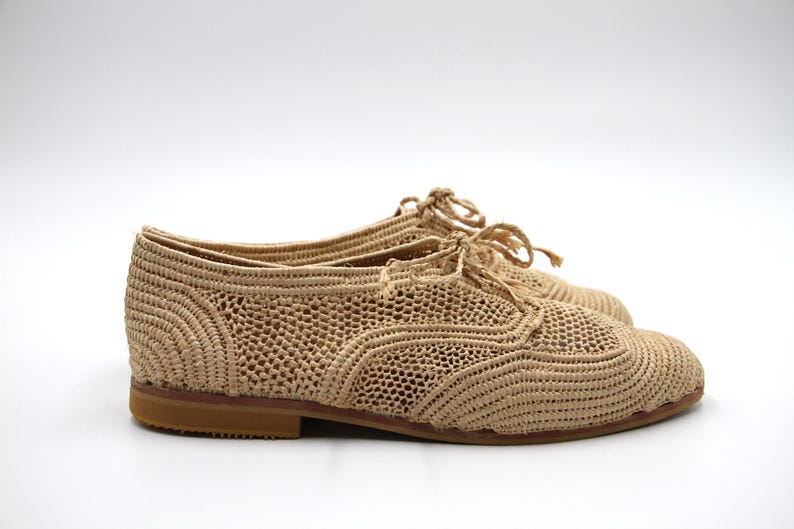 May include: Beige crocheted lace-up shoes with a rounded toe and a low heel.