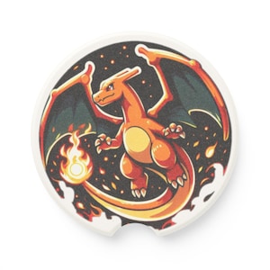 May include: A round ceramic car coaster with a cartoon image of a red and orange dragon with wings and a tail of fire. The dragon is flying in a dark blue sky with stars and a trail of fire.