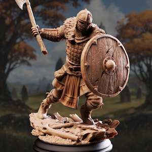 May include: A detailed figurine of a Viking warrior in a battle stance, holding an axe and shield. The figure is clad in armor and a helmet, with a fur-lined collar. The shield is round and wooden, and the base features a landscape with fallen branches.