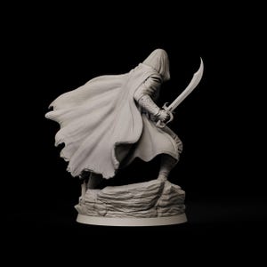 May include: A detailed figurine of a cloaked figure holding a curved sword, posed as if in action. The figure is standing on a rocky base, with the cloak flowing dramatically. The color is a neutral gray, set against a black background.