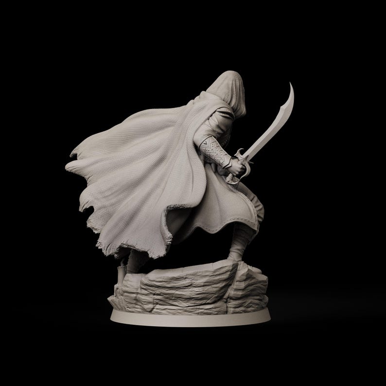 May include: A detailed figurine of a cloaked figure holding a curved sword, posed as if in action. The figure is standing on a rocky base, with the cloak flowing dramatically. The color is a neutral gray, set against a black background.