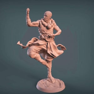 May include: A light brown figurine of a bald monk in a dynamic pose. The monk is wearing a robe and pants, with a beaded necklace and a belt. The figurine is on a circular base, with one leg raised.