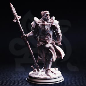 May include: A detailed figurine of a warrior in ornate armor, holding a spear. The figure is in a dynamic pose, standing on a textured base. The armor features intricate designs, and the overall color is a muted, neutral tone.
