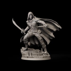 May include: A detailed figurine of a hooded figure holding two curved swords, posed on a rocky base. The figure is clad in a tunic, pants, and a flowing cape. The sculpture is monochromatic, with a focus on texture and form.