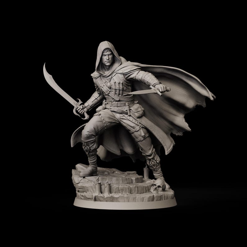 May include: A detailed figurine of a hooded figure holding two curved swords, posed on a rocky base. The figure is clad in a tunic, pants, and a flowing cape. The sculpture is monochromatic, with a focus on texture and form.