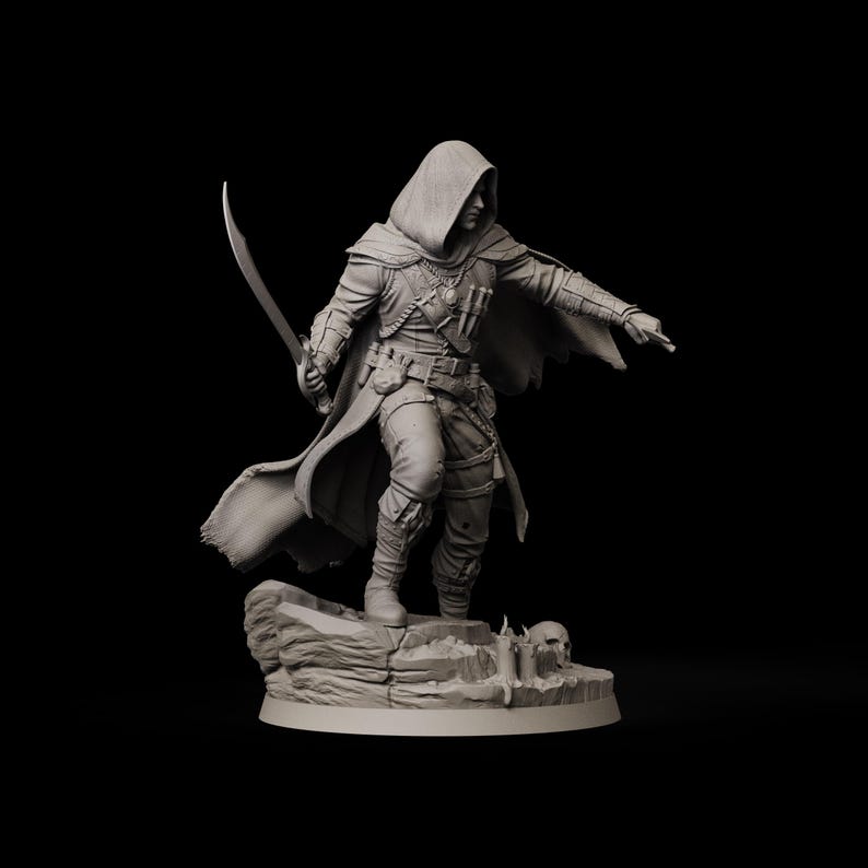 May include: A detailed figurine of a robed figure holding a curved sword, standing on a rocky base. The figure is wearing a hooded cloak and detailed armor, with a belt and pouches. A skull is visible near the base. The figure is pointing with their right hand.