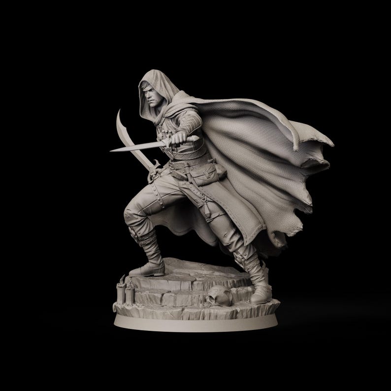 May include: A detailed figurine of a hooded figure in a dynamic pose, holding two curved blades. The figure is clad in a long cloak and detailed clothing, standing on a stone base with a skull. The overall color is a muted gray.