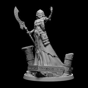 May include: A gray painted miniature figurine of a female figure with a staff and a flowing robe, standing on a base with a stone texture.